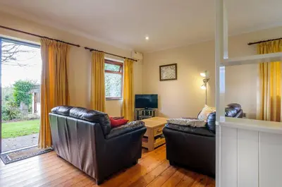 a living room with two leather chairs and a television at Shilbury Retreat Cottage near Perranporth in Perranporth