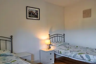 a bedroom with two beds and a lamp on a night stand at Finest Retreats - Trippet Cottage at Bodmin Moor in Saint Breward