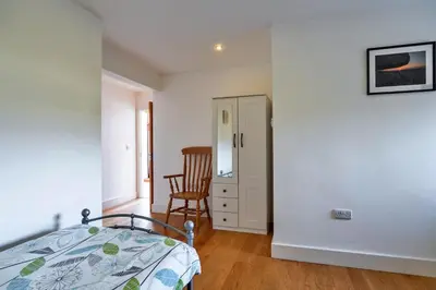a bedroom with a bed and a chair at Finest Retreats - Trippet Cottage at Bodmin Moor in Saint Breward