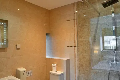a bathroom with a toilet and a glass shower at Finest Retreats - Trippet Cottage at Bodmin Moor in Saint Breward