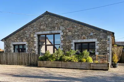 a stone house with plants in front of it at Finest Retreats - Trippet Cottage at Bodmin Moor in Saint Breward