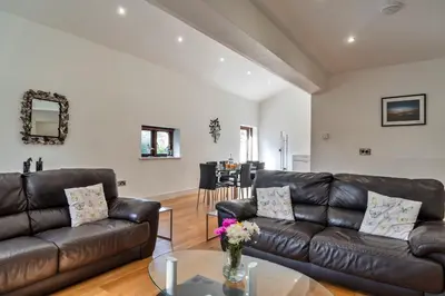 a living room with a leather couch and a table at Finest Retreats - Jubilee Cottage at Bodmin Moor in Saint Breward