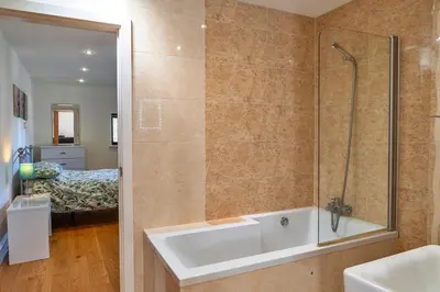 a bathroom with a tub and a shower and a bed at Finest Retreats - Jubilee Cottage at Bodmin Moor in Saint Breward