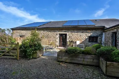a brick house with solar panels on the roof at Finest Retreats - Jubilee Cottage at Bodmin Moor in Saint Breward
