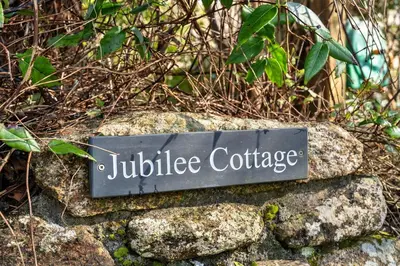 a sign sitting on top of some rocks at Finest Retreats - Jubilee Cottage at Bodmin Moor in Saint Breward