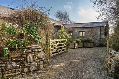 a stone house with a gate and a stone wall at Finest Retreats - Jubilee Barn Cottage at Bodmin Moor in Saint Breward