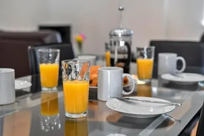 a table with two glasses of orange juice on it at Finest Retreats - Jubilee Barn Cottage at Bodmin Moor in Saint Breward