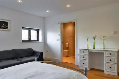 a living room with a couch and a table with flowers at Finest Retreats - Jubilee Barn Cottage at Bodmin Moor in Saint Breward