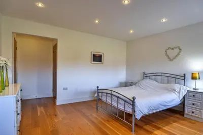 a bedroom with a bed and a wooden floor at Finest Retreats - Jubilee Barn Cottage at Bodmin Moor in Saint Breward