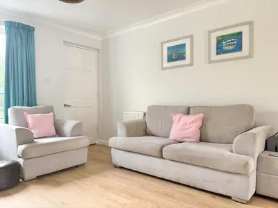a living room with a couch and a chair at Falmouth Oasis with sub-tropical garden & parking in Falmouth