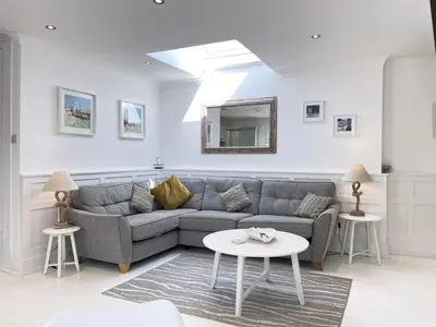 a living room with a couch and a table at 4 Hazelbury House - a tranquil hidden gem in St Ives