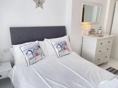 a white bed with two pillows on top of it at 4 Hazelbury House - a tranquil hidden gem in St Ives