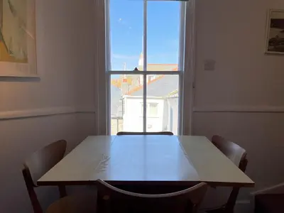 a table and chairs in a room with a window at 2 Upper Meadow - near to Porthmeor Beach in St Ives