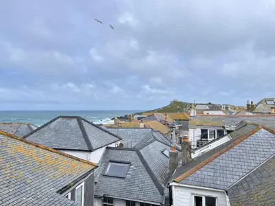 a view of roofs of houses and the ocean at 2 Upper Meadow - near to Porthmeor Beach in St Ives