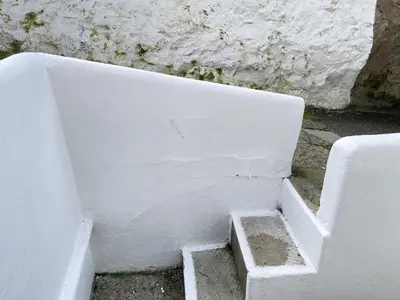 a white wall with some stairs in a room at 2 Upper Meadow - near to Porthmeor Beach in St Ives