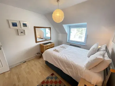 a small bedroom with a bed and a mirror at 51-52 Carrack Widden in St Ives