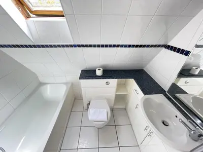 a white bathroom with a toilet and a sink at 51-52 Carrack Widden in St Ives