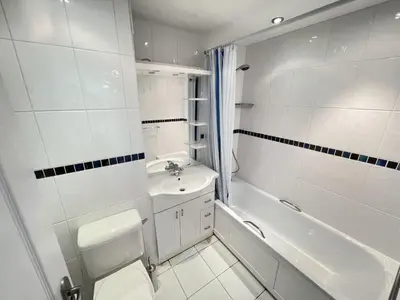 a white bathroom with a sink and a tub and a toilet at 51-52 Carrack Widden in St Ives