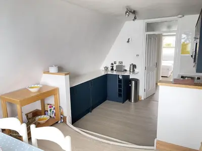 a small kitchen with blue cabinets and a table at 51-52 Carrack Widden in St Ives