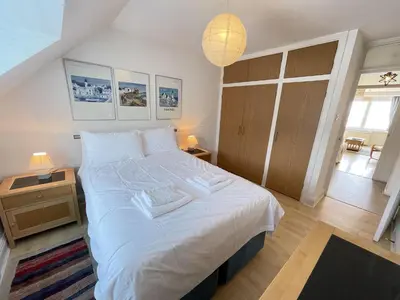 a bedroom with a large bed with white sheets at 51-52 Carrack Widden in St Ives