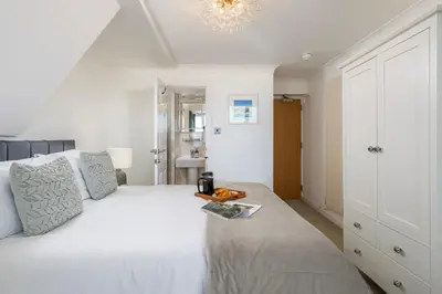 a bedroom with a white bed with a table on it at Blue Mist House in St Ives