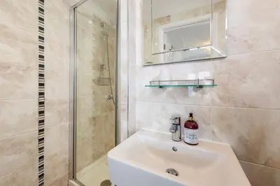 a bathroom with a white sink and a shower at Blue Mist House in St Ives