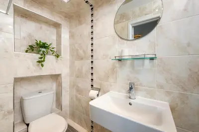 a bathroom with a toilet and a sink and a mirror at Blue Mist House in St Ives