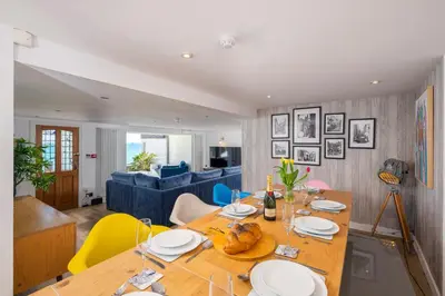 a dining room and living room with a table and chairs at Blue Mist House in St Ives