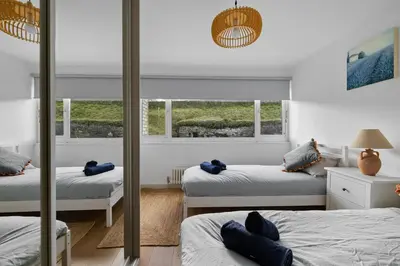 a bedroom with two beds and a window at 5 Mermaid Court in Newquay
