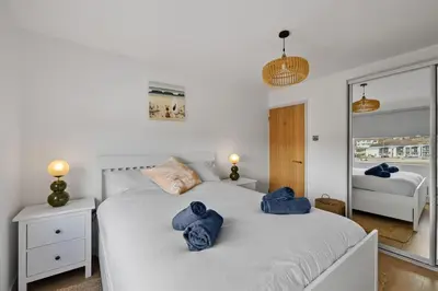 two beds in a bedroom with blue towels on them at 5 Mermaid Court in Newquay