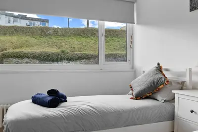 a bedroom with a bed with a window at 5 Mermaid Court in Newquay