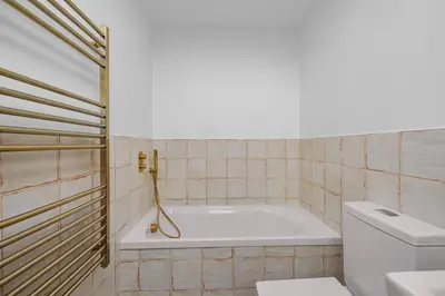a bathroom with a bath tub and a toilet at 5 Mermaid Court in Newquay