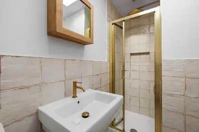 a bathroom with a sink and a mirror and a shower at 5 Mermaid Court in Newquay