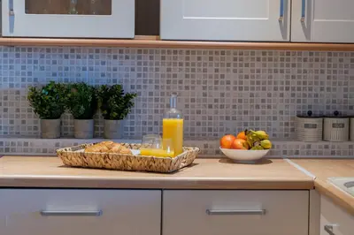 a kitchen counter with a basket of fruit and a bottle of orange juice at Flat 17, The Stones in St Ives