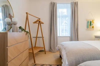 a bedroom with a bed and a dresser and a mirror at Flat 17, The Stones in St Ives