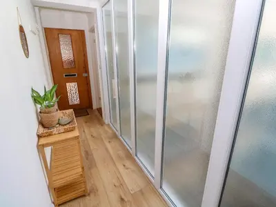 a glass shower in a room with a wooden floor at Flat 17, The Stones in St Ives