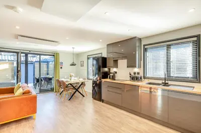 a kitchen and living room with a couch and a table at Lerryn Lodge, The Vale, Cornwall in Looe