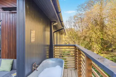 a balcony of a house with a bench on it at Lerryn Lodge, The Vale, Cornwall in Looe