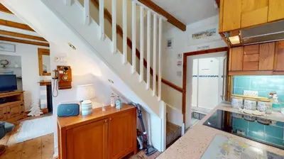 an attic kitchen with a staircase and a stair case at Hayle Saffron Cottage 2 Bedrooms in Hayle