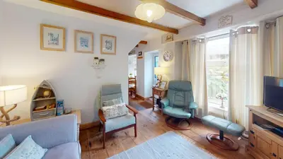a living room with two chairs and a television at Hayle Saffron Cottage 2 Bedrooms in Hayle