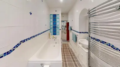 a white bathroom with a tub and a sink at Hayle Saffron Cottage 2 Bedrooms in Hayle