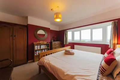 a bedroom with a large bed and a window at 5 Bedroom House with Sea Views in Penryn