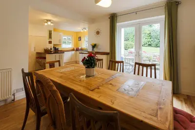 a kitchen and dining room with a wooden table and chairs at 5 Bedroom House with Sea Views in Penryn