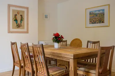 a dining room with a wooden table and chairs at 5 Bedroom House with Sea Views in Penryn