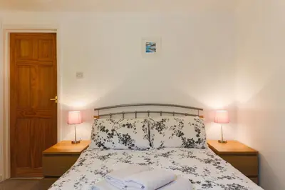a bedroom with a bed with two lamps on night stands at 5 Bedroom House with Sea Views in Penryn