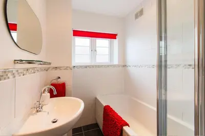 a white bathroom with a tub and a sink at 5 Bedroom House with Sea Views in Penryn