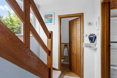 a hallway with a wooden door and a staircase at Blue Haze - Family accommodation with private beach access in Charlestown