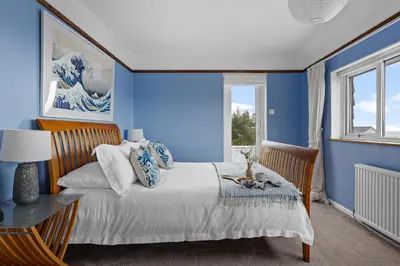 a blue bedroom with a bed and a table at Blue Haze - Family accommodation with private beach access in Charlestown