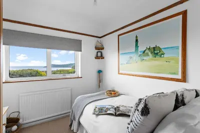 a bedroom with a bed and a large window at Blue Haze - Family accommodation with private beach access in Charlestown