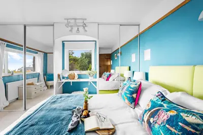 a bedroom with blue walls and a large bed at Blue Haze - Family accommodation with private beach access in Charlestown